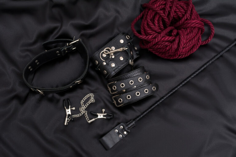 Leather handcuffs, shibari rope, nipple clamps, chain collar and stack on black